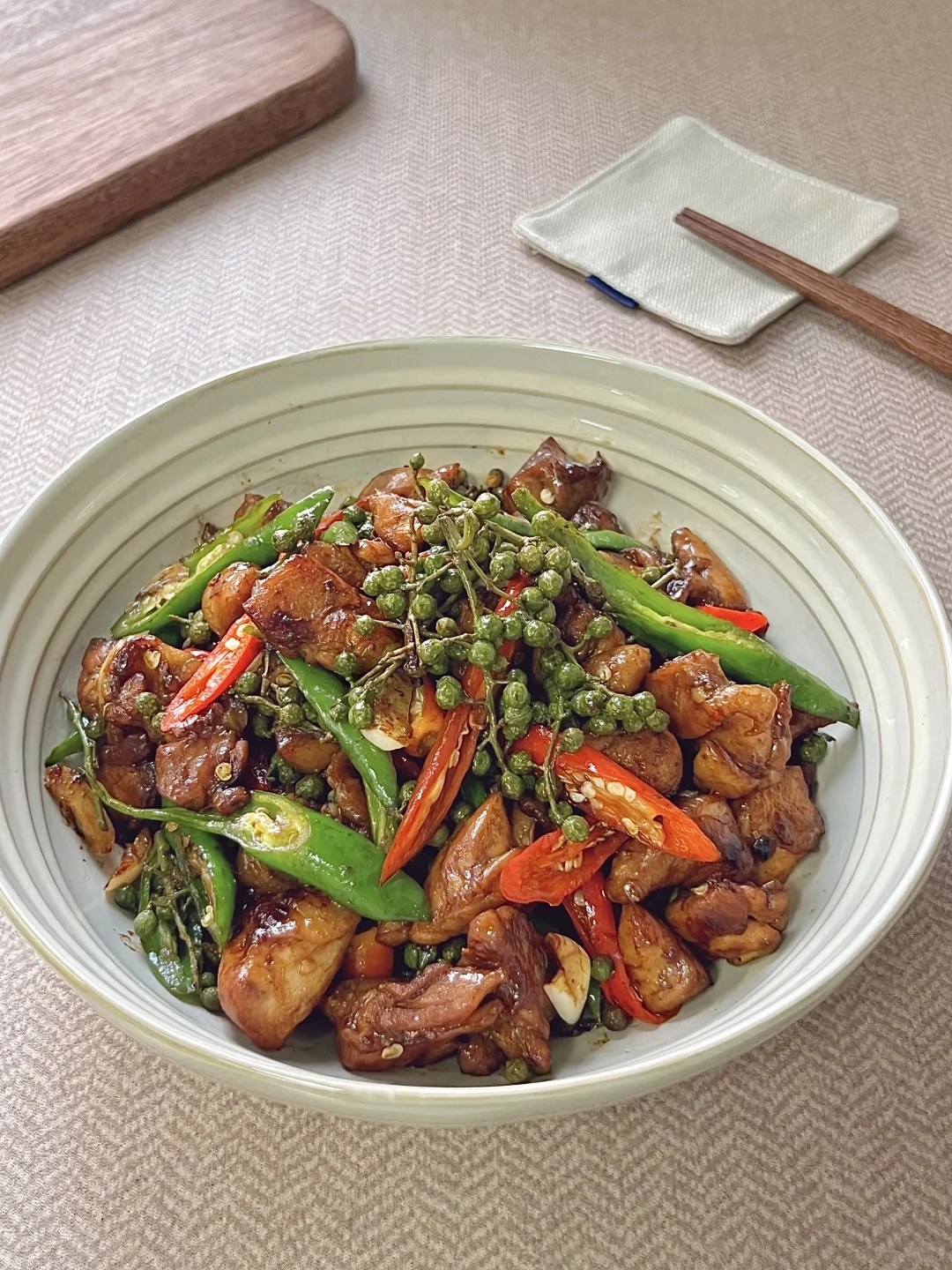 Chicken pieces with green and red chiles and green peppercorns.