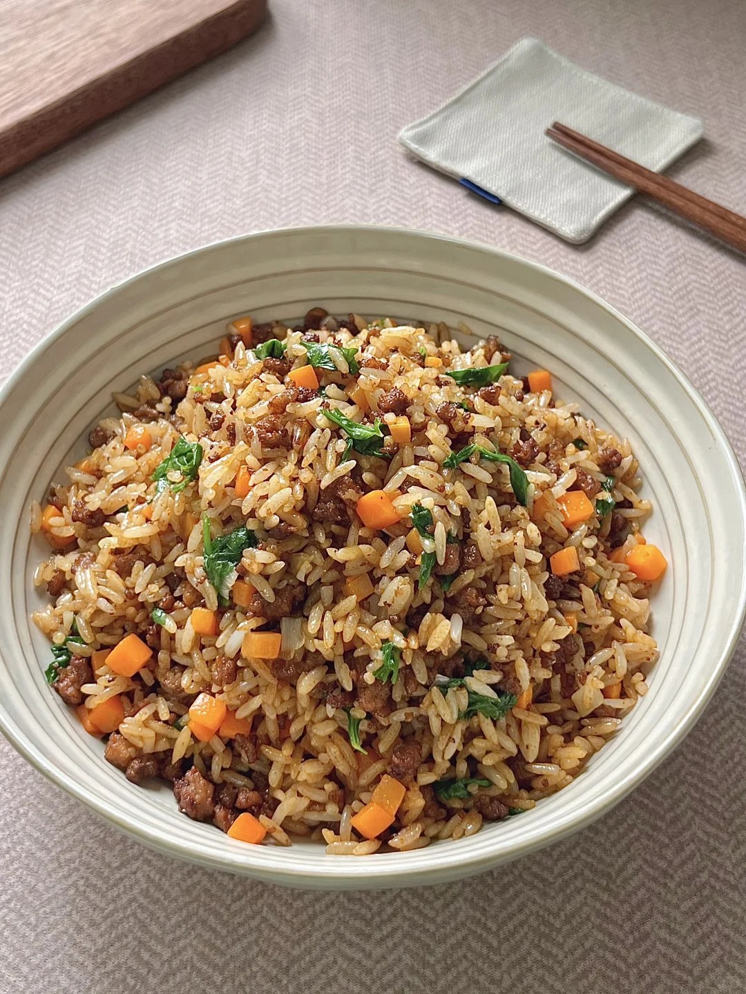 Fried rice with ground beef, diced vegetables and green herbs.