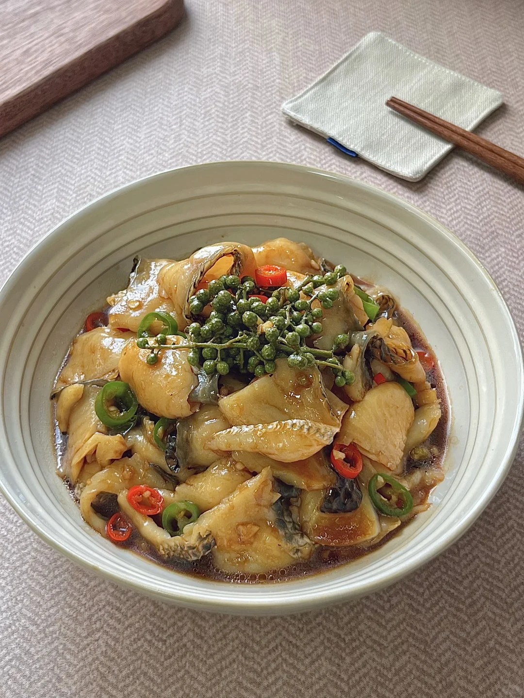 Fish slices with green and red chiles in a light glossy sauce.