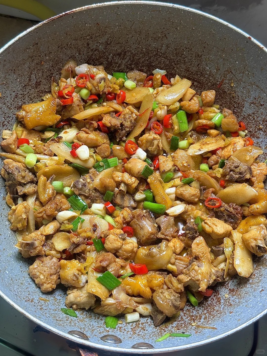 Small browned chicken pieces with chopped ginger and red and green chiles.