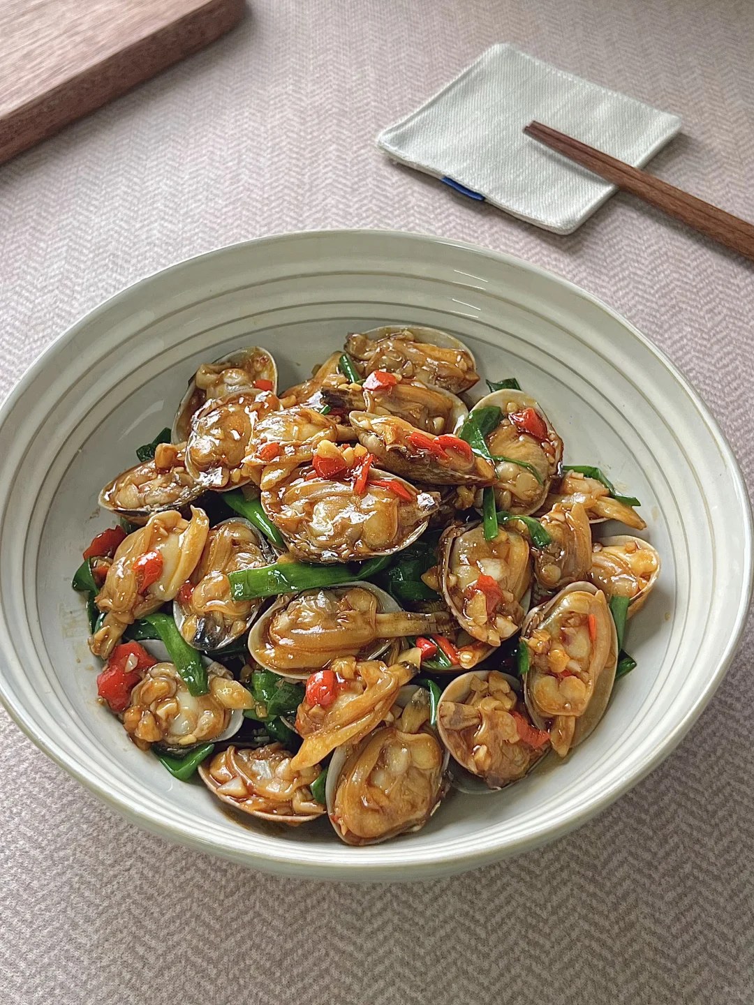 Opened clams with chopped garlic, red chiles and scallions.