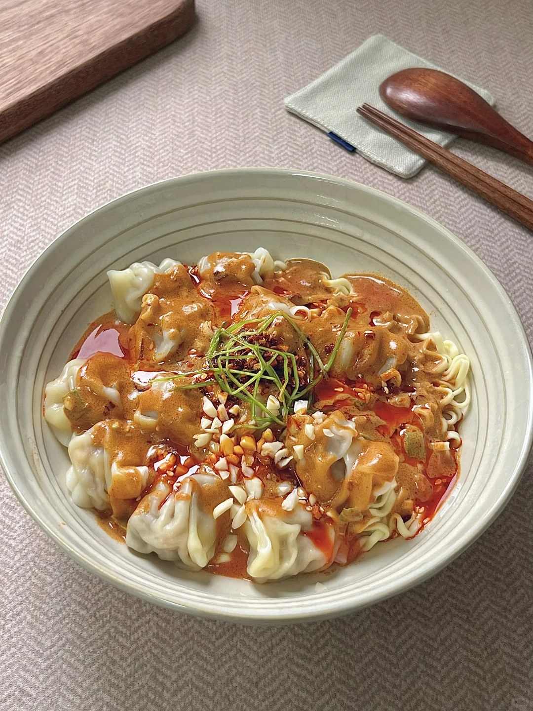 Wontons and noodles coated in sesame sauce with chopped peanuts.