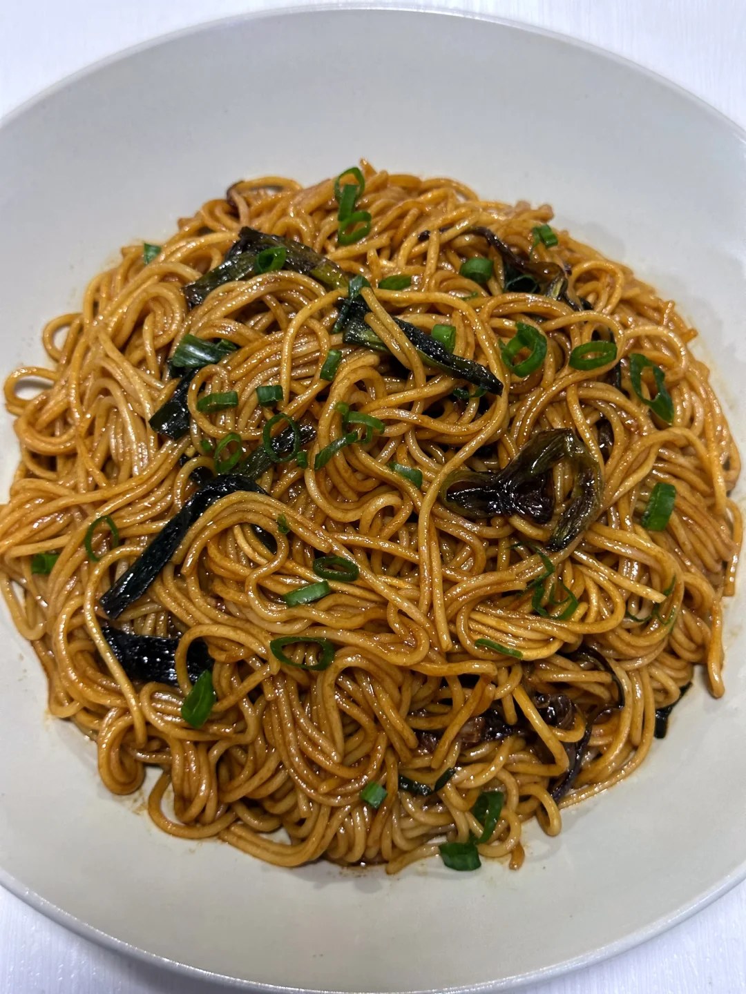 Brown sauced noodles with dark fried scallion strips.