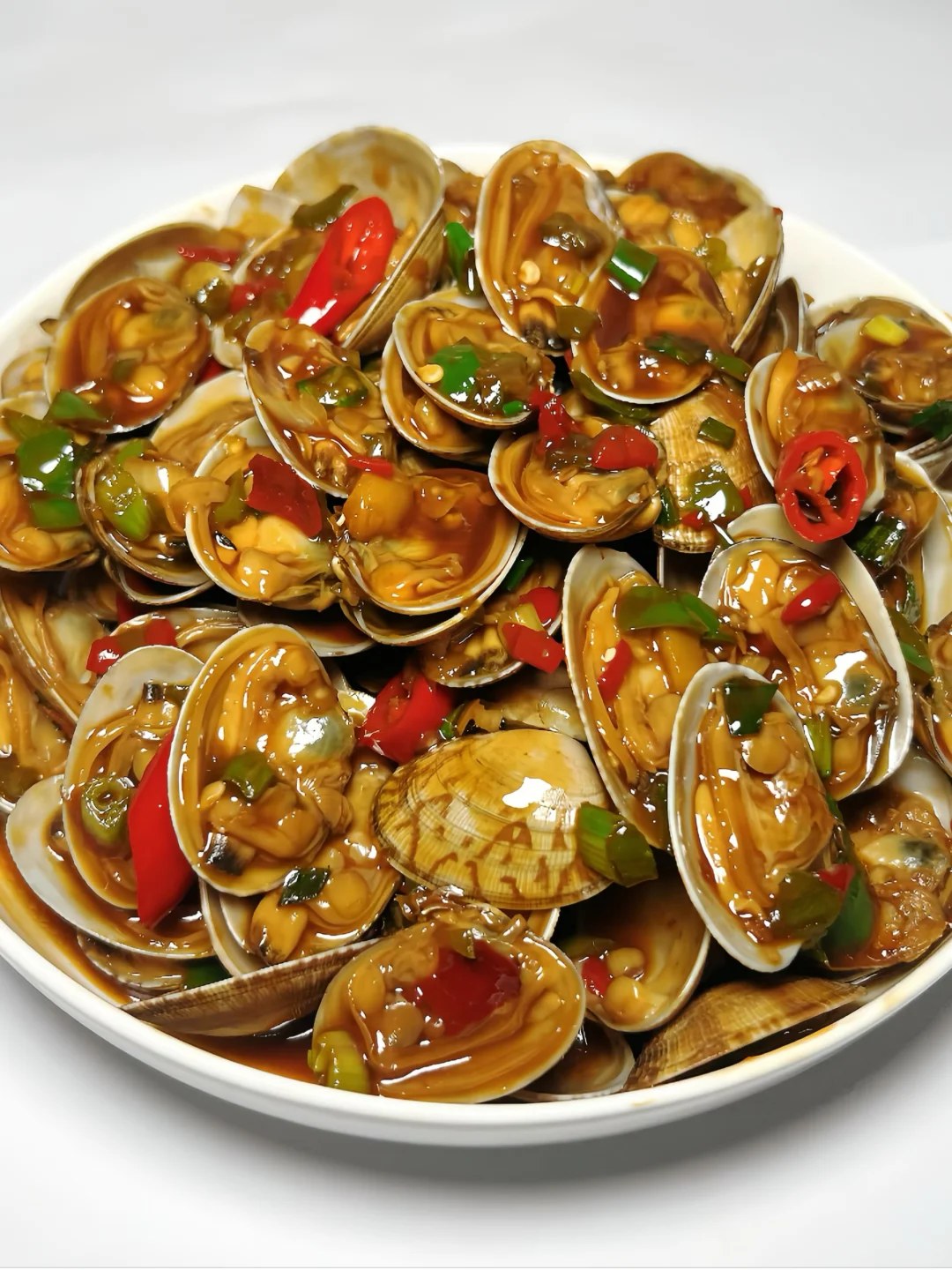 Opened clam shells with green and red chiles and scallions.