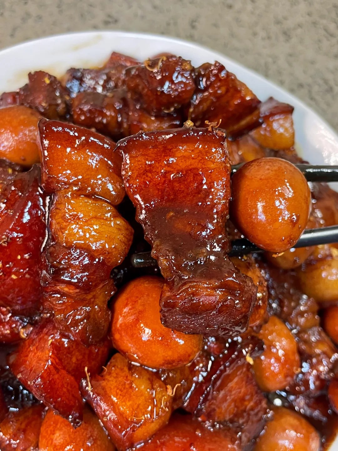 Glazed pork belly cubes and quail eggs coated in a dark sauce.